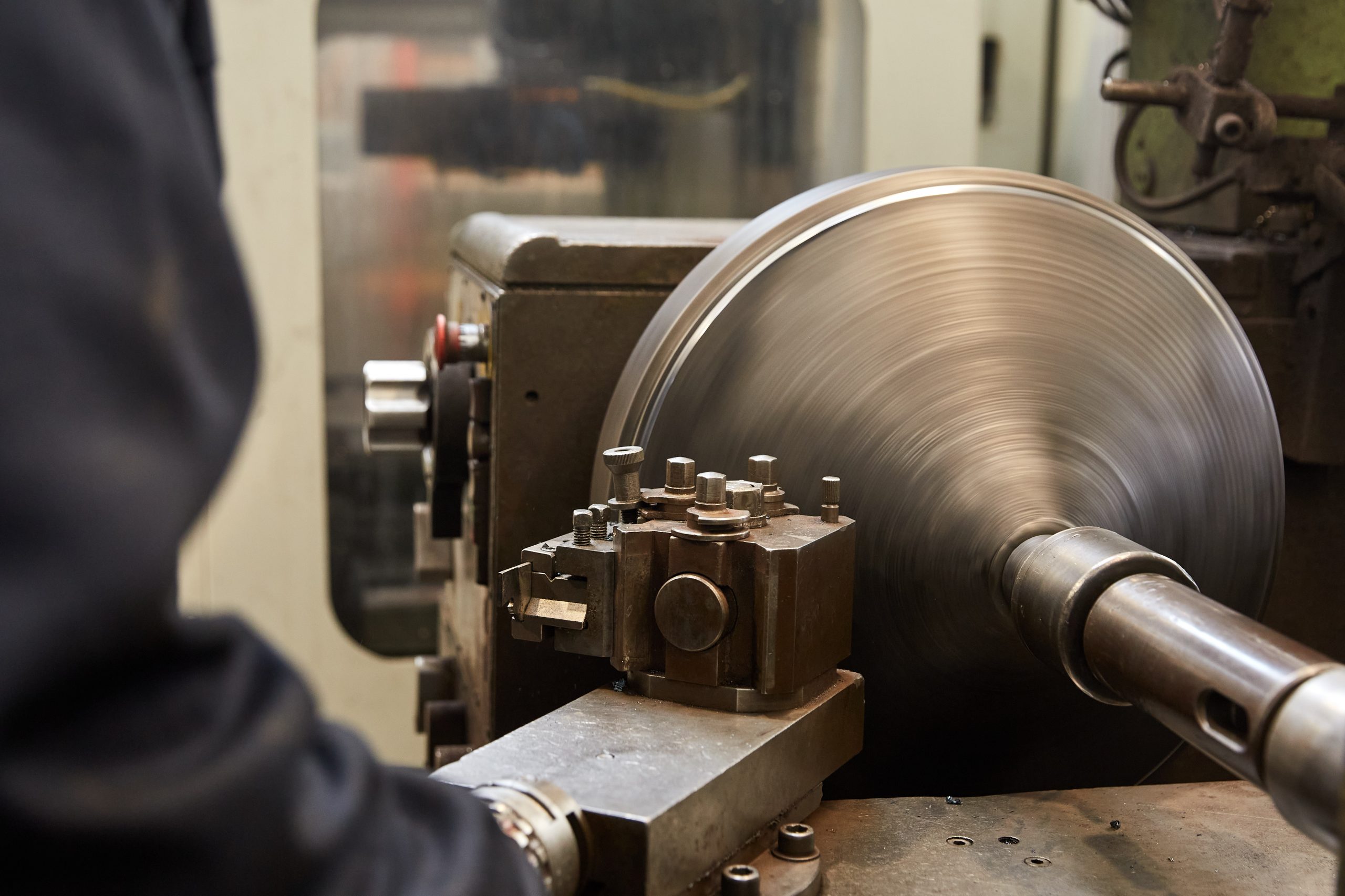 Close up of a metal spinning machine in the process of spinning a part